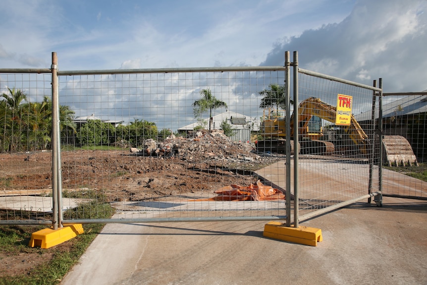 A fenced off demolition site in Palmerston with the rubble of a former house visible.