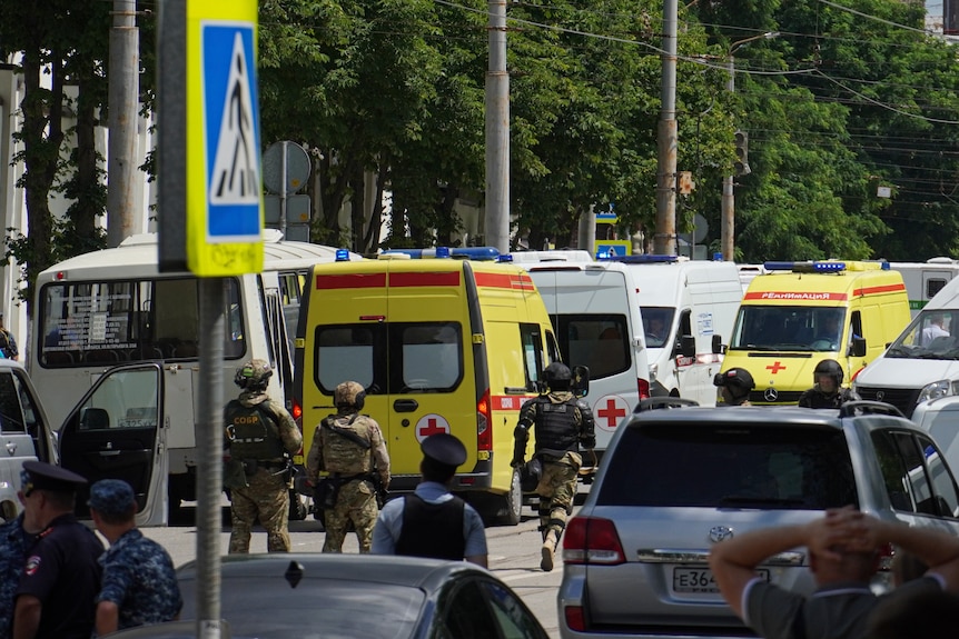 Russian police stand next to medical cars