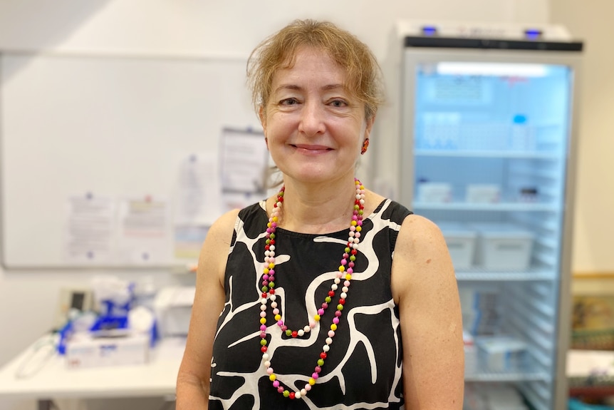 A woman standing in front of a medical fridge