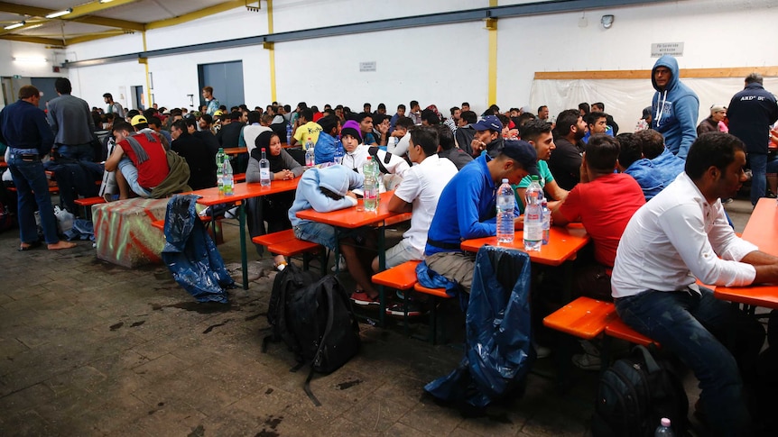 Dozens of people rest at tables