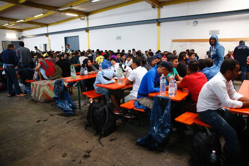 Dozens of people rest at tables