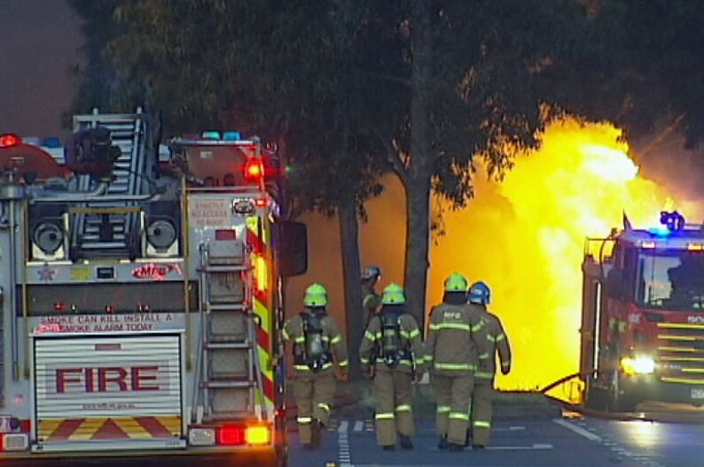 Ground shots of cement mixer in flames with emergency crews on scene