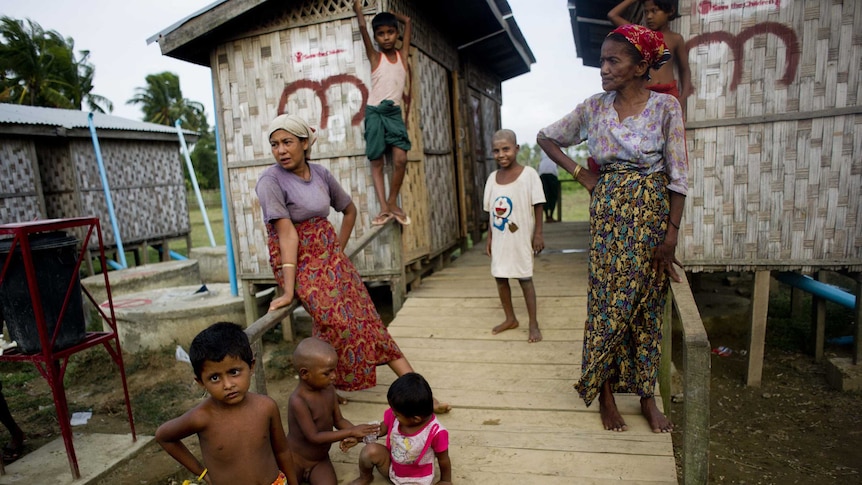 Rohingya Muslims stand near shelters at a camp.