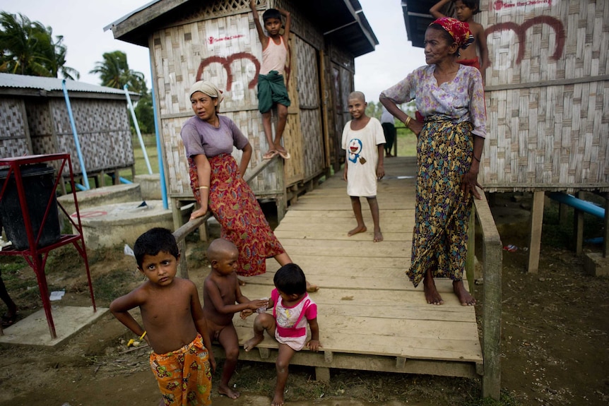 Rohingya Muslims stand near shelters at a camp.