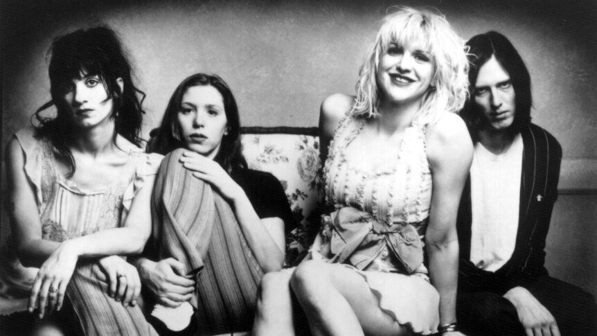 Press photo of American band Hole, black and white photo of four band members sitting on a couch