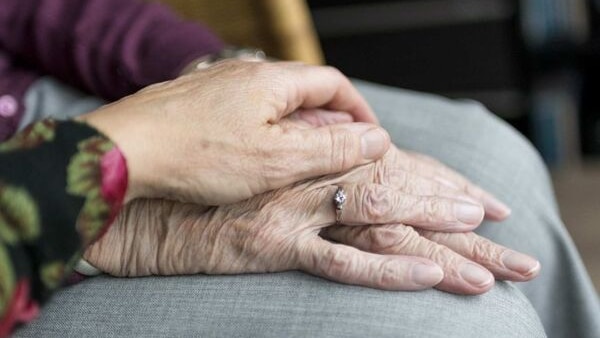 older persons hands being held by a younger persons hands a caring image