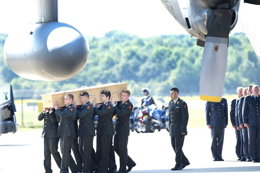 Military men carry a coffin containing the remains of a victim of downed Malaysia Airlines flight MH17.