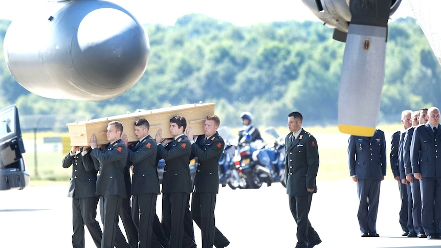 Military men carry a coffin containing the remains of a victim of downed Malaysia Airlines flight MH17.
