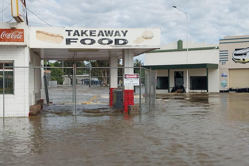 Floodwaters through businesses in a country town.
