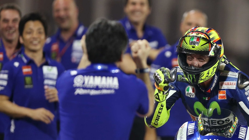 Yamaha rider Valentino Rossi (R) celebrates with his team after winning the 2015 Qatar MotoGP.