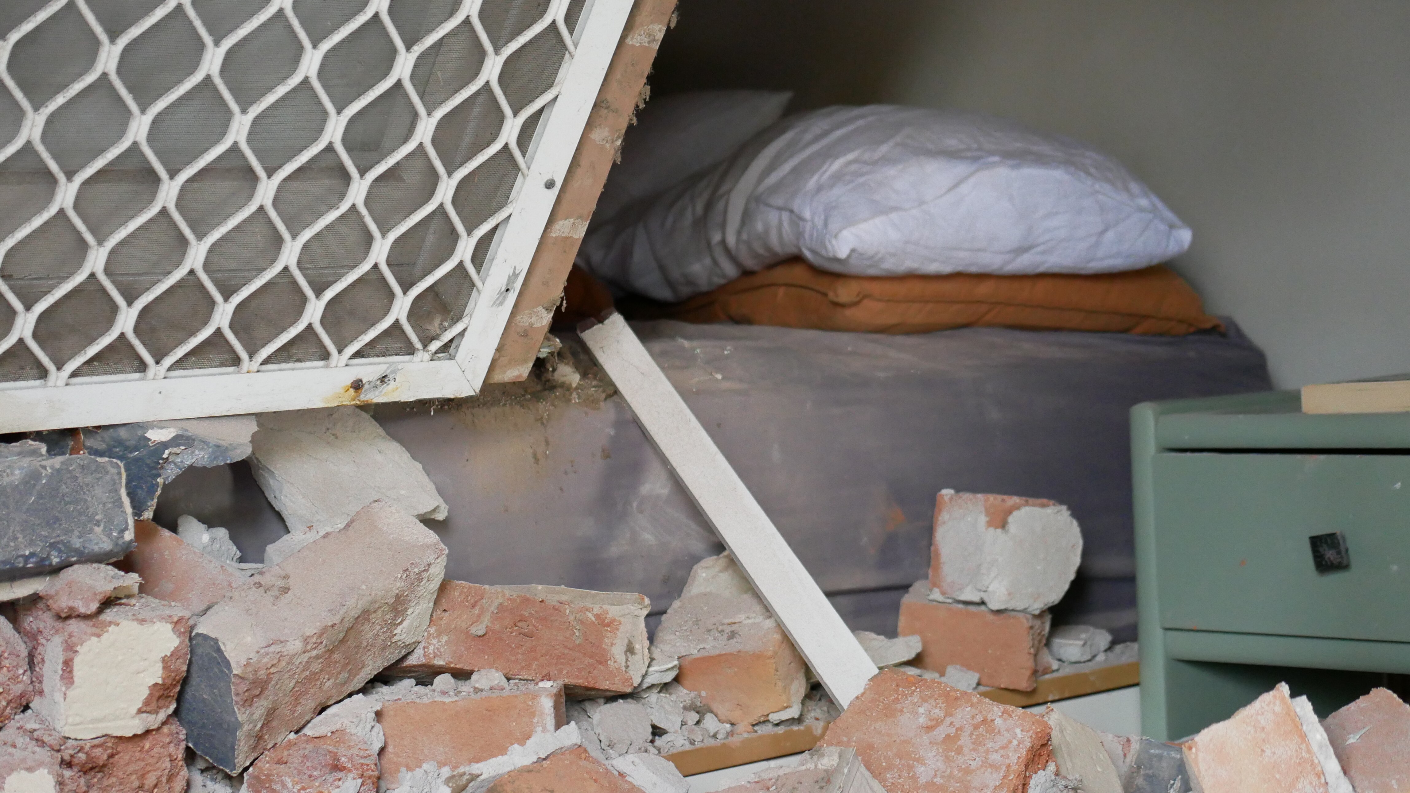 A pillow can be seen behind a rubble of bricks. 