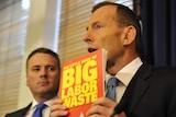 Tony Abbott holds up the Coalition's book, The Little Book of Big Labor Waste