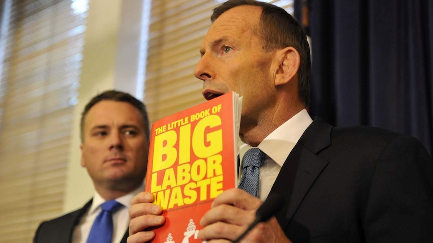 Tony Abbott holds up the Coalition's book, The Little Book of Big Labor Waste