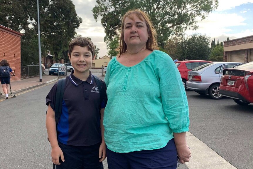 A mother and son in a school car park