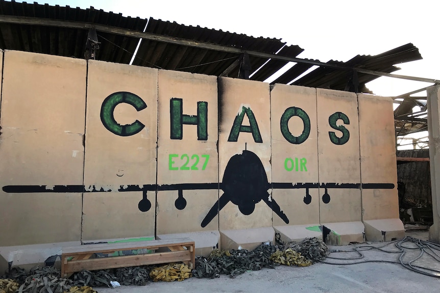The words "CHAOS" and a military plane are drawn on a wall