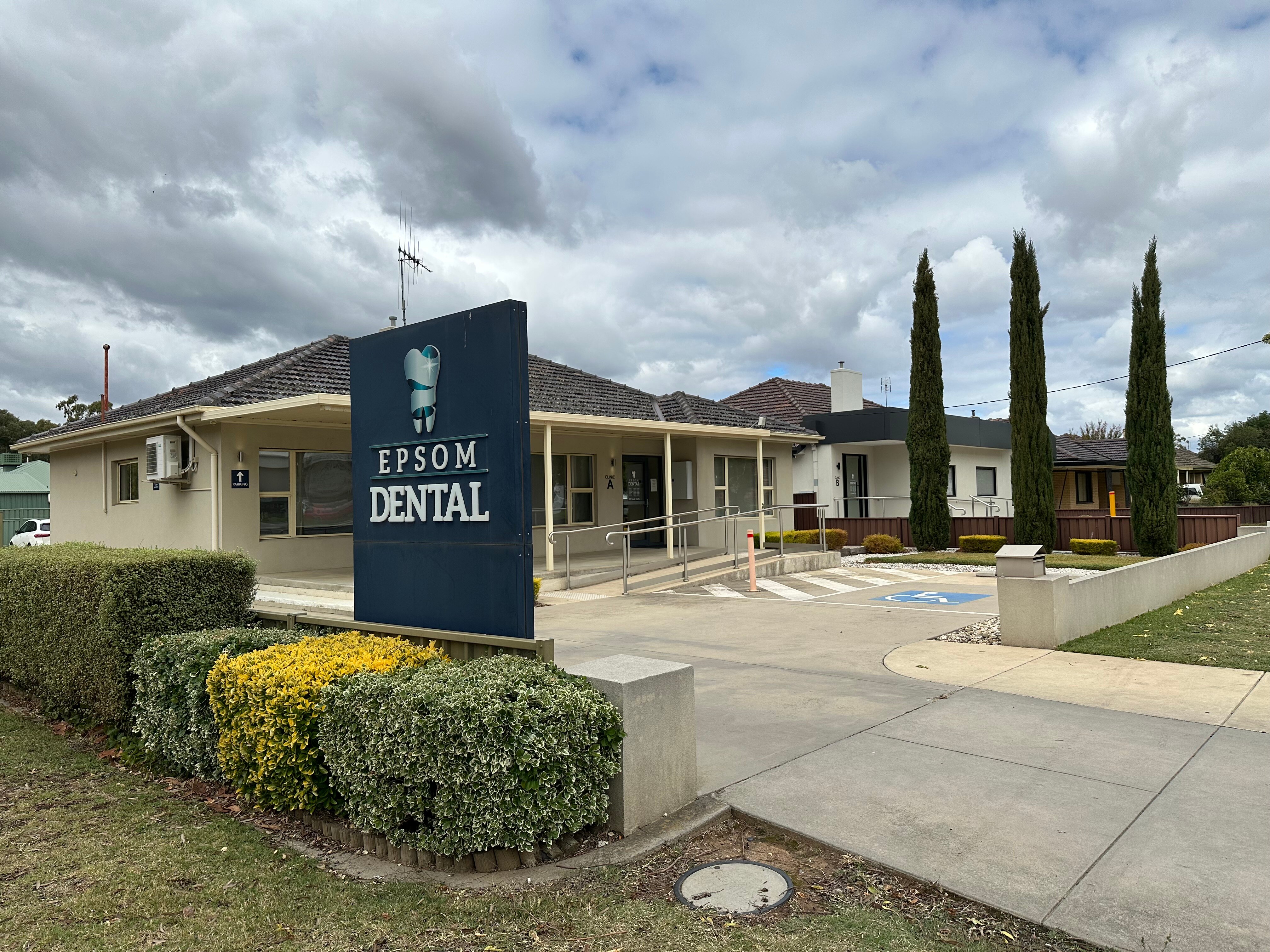 The outside of a dental surgery, with a sign out the front saying 'Epsom Dental'.