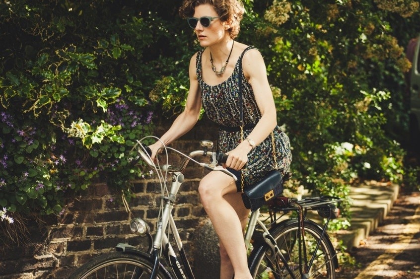 Woman riding a bicycle for a story about the bare minimum amount of exercise you need to stay healthy.