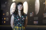 A woman in front of a poster of various astronomical features