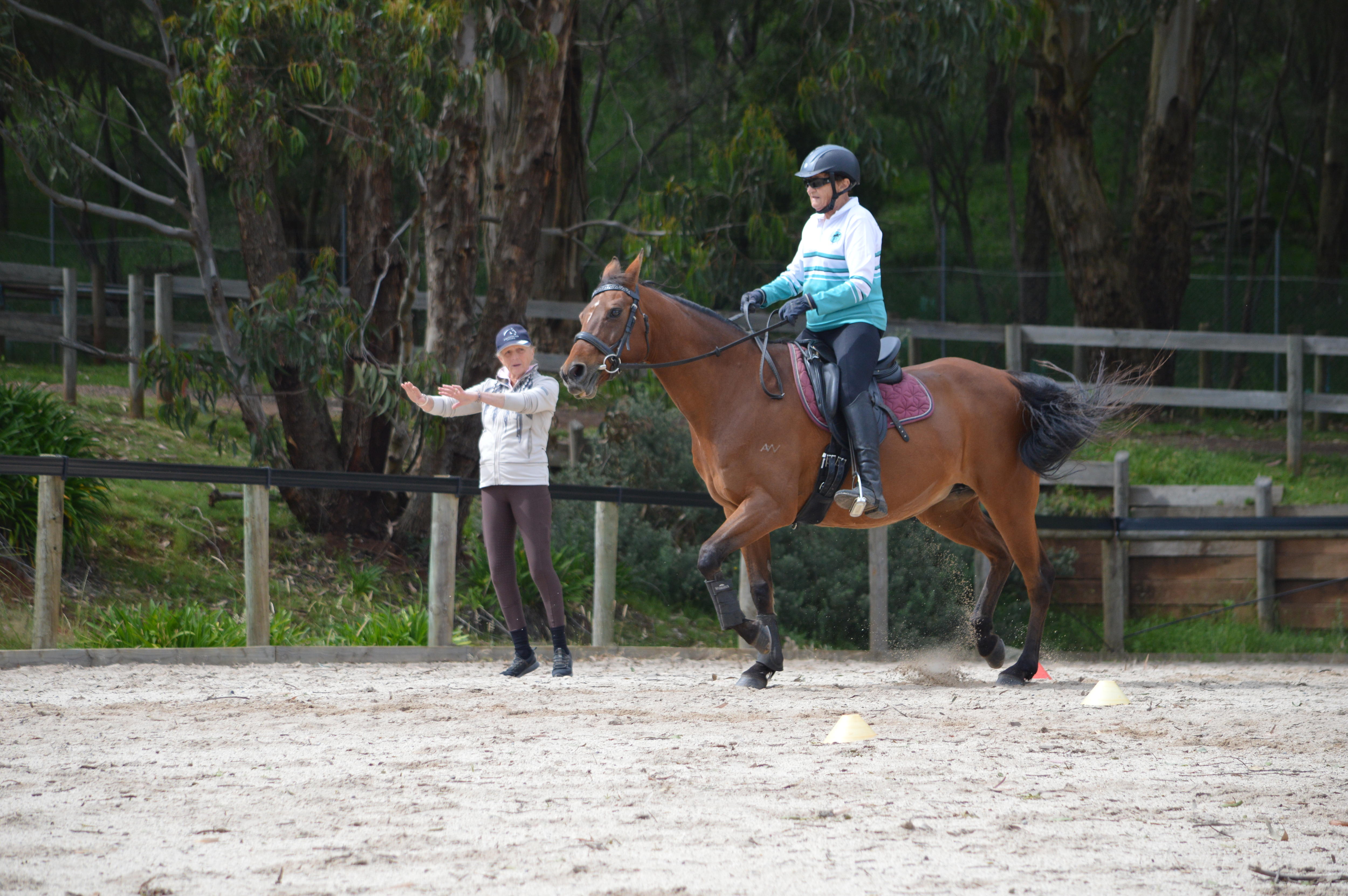 Joan Jeffery anda a cavalo enquanto outro membro do clube oferece conselhos