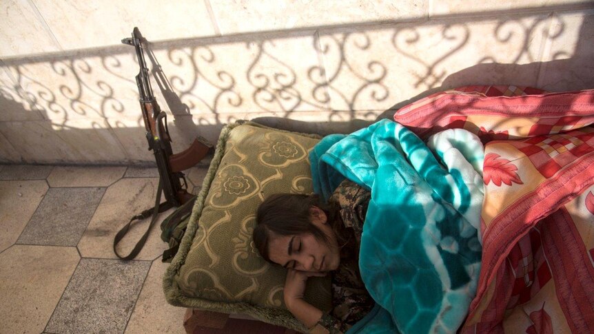 A YPJ member sleeps on the balcony of a house they use as a base in Raqqa.