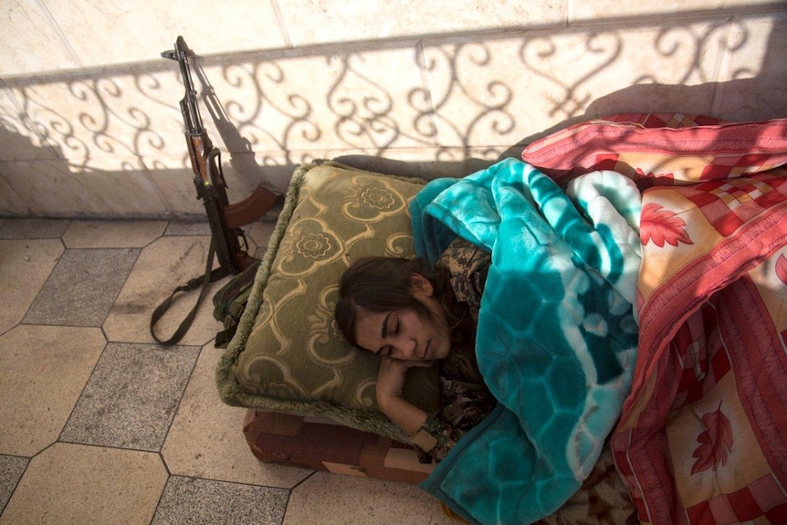 A YPJ member sleeps on the balcony of a house they use as a base in Raqqa.