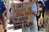 A placard at a march saying 'I can't believe we still have to march, women are being killed!'