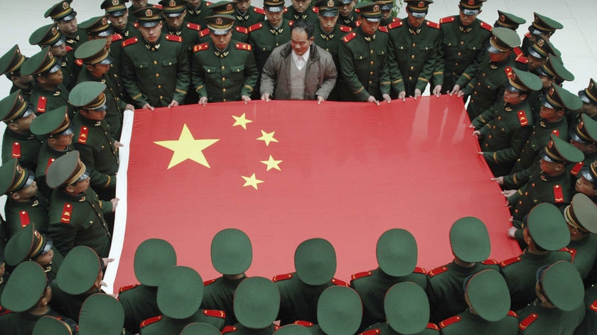 Paramilitary soldiers hold a Chinese national flag along with Jiang Xinglin at an army base.