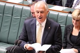 Prime Minister Malcolm Turnbull flips through paper in Parliament