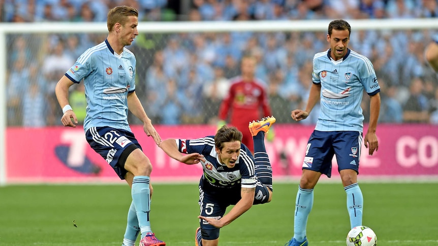 Marc Janko of Sydney FC tackles Mark Milligan of Victory
