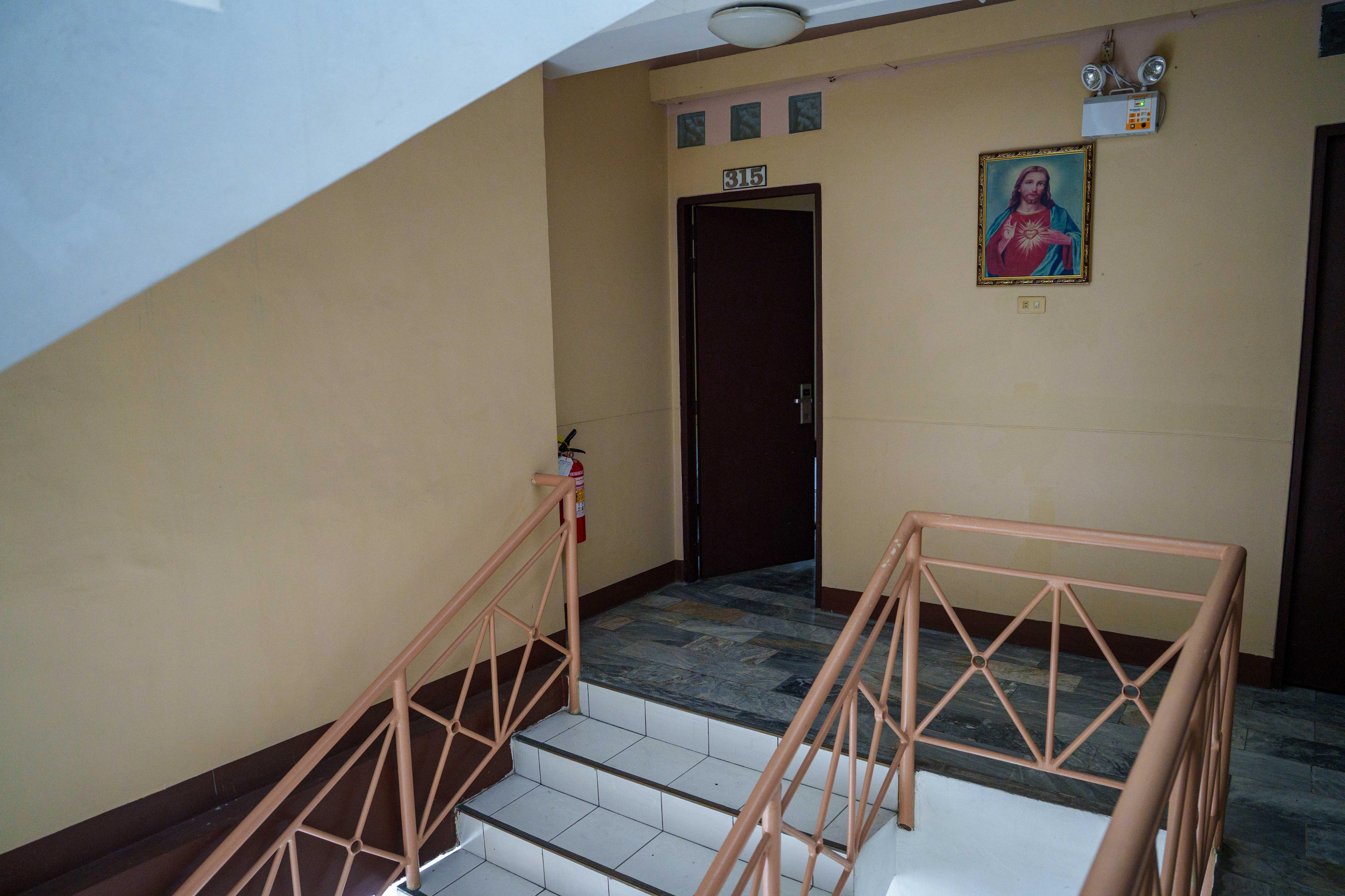 Uma porta tem 315 acima da porta e uma imagem de Jesus está pendurada na parede.