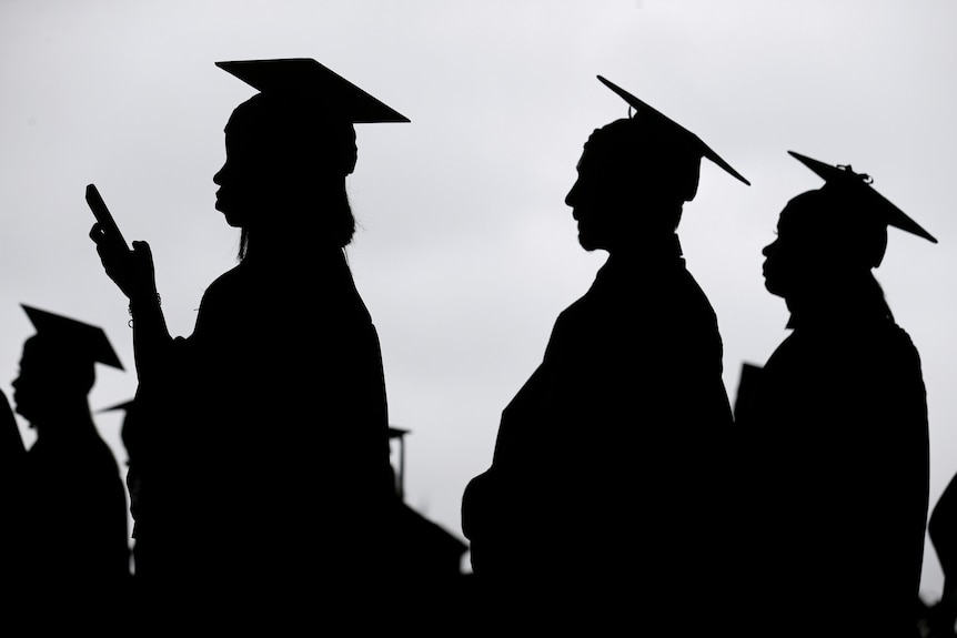 A silhouette shows graduate students wearing gowns and hats.