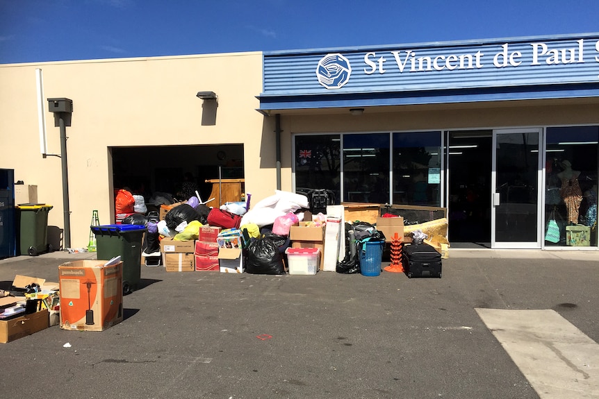 Piles of donated items dumped outside a charity store