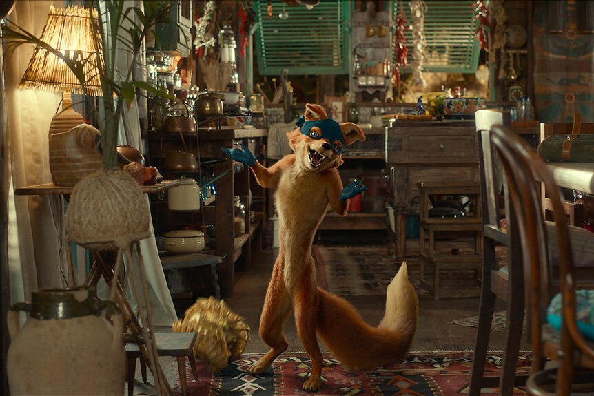 An animated fox with mask and gloves gestures in a cluttered kitchen and dining space.