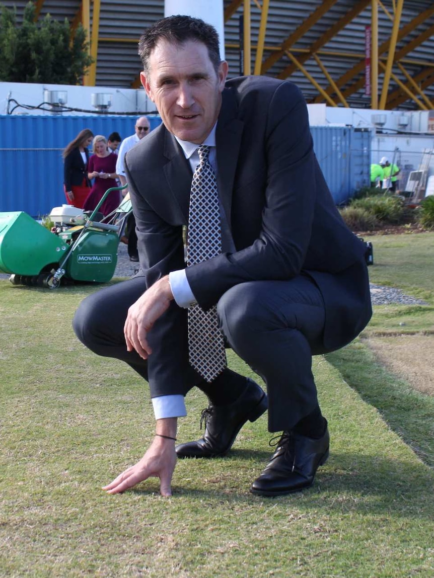 James Sutherland looks to the cameras as he inspects a pitch outside Carrara stadium.