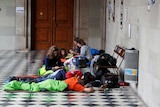 People wake up after spending the night inside the University of Barcelona. They are in sleeping bags.