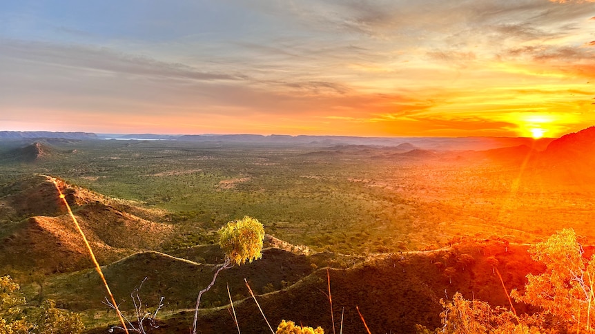 Landscape picture of red Kimberley hills and green valleys at sunset