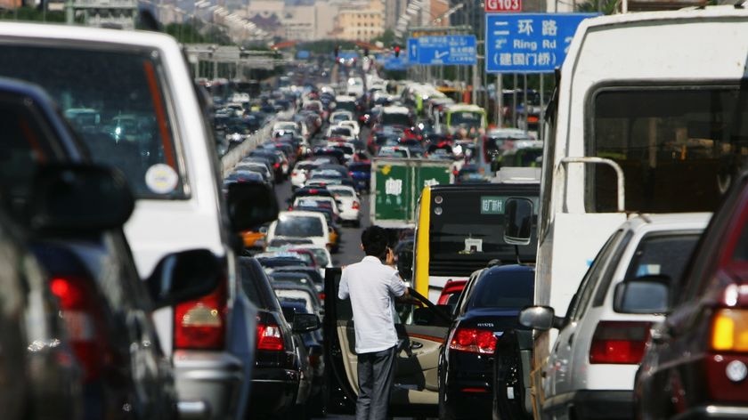 A Chinese driver checks out a heavy traffic jam in Beijing