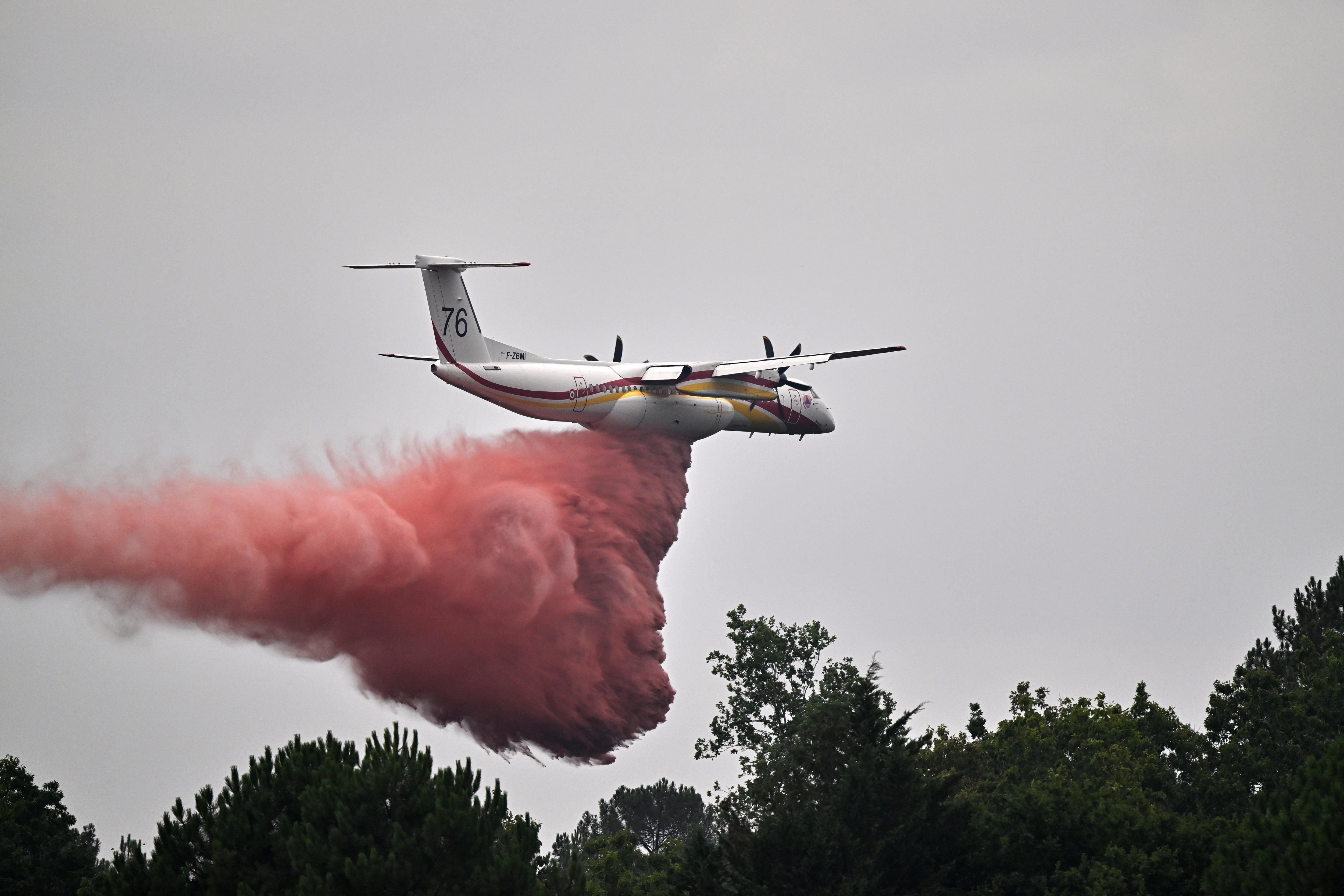 A huge amount of red-coloured water falls from an airplane.