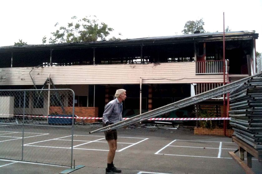 A worker moves portable fencing at Mansfield State School after a fire almost destroyed the school