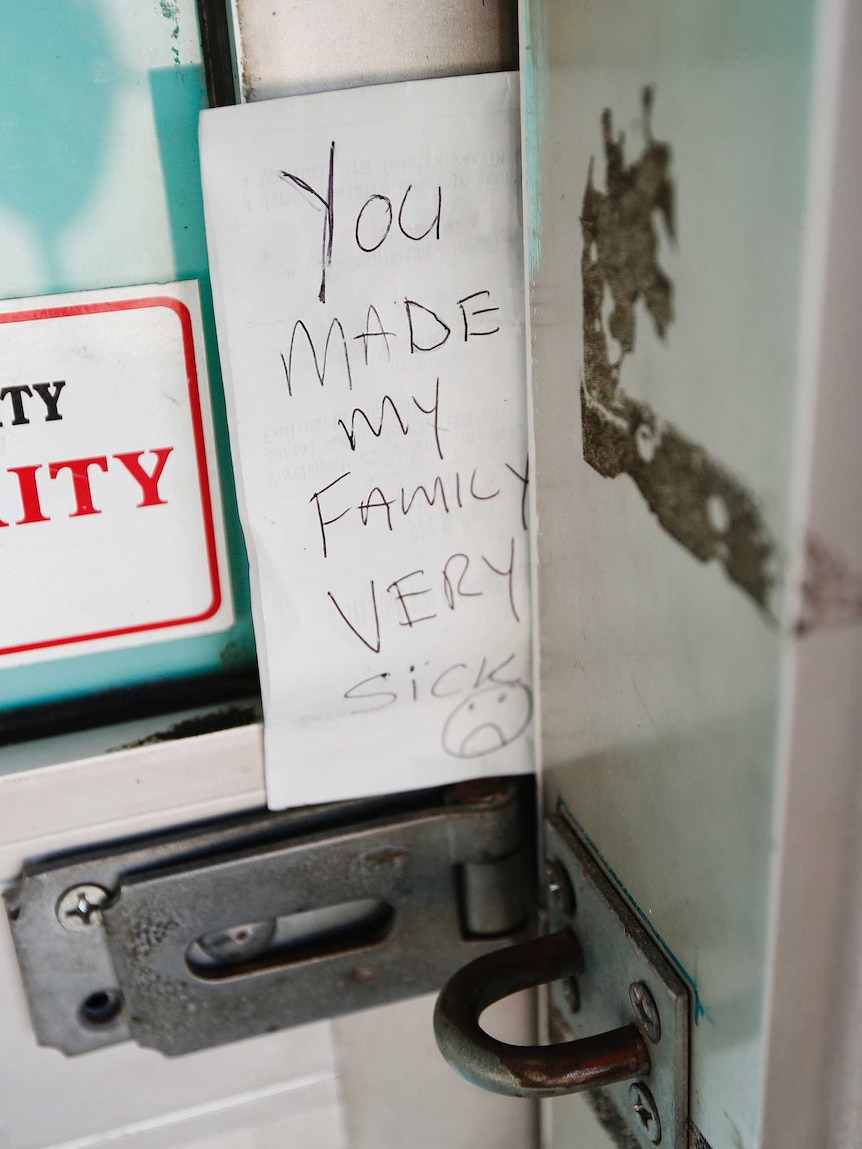 A handwritten note left at the Box Village Bakery reads "you made my family very sick".