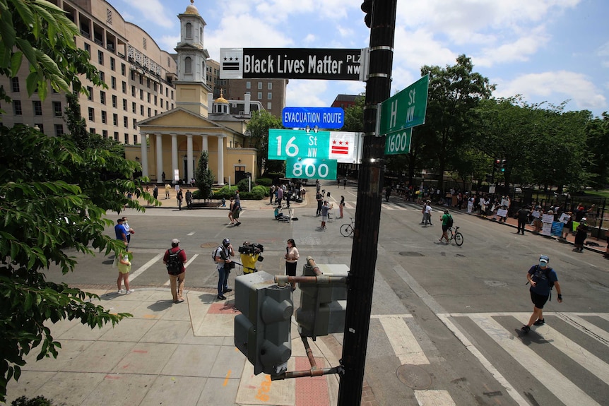 A street sign can be seen with a church building in the background