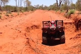 a quad bike in a hole in a dirt road