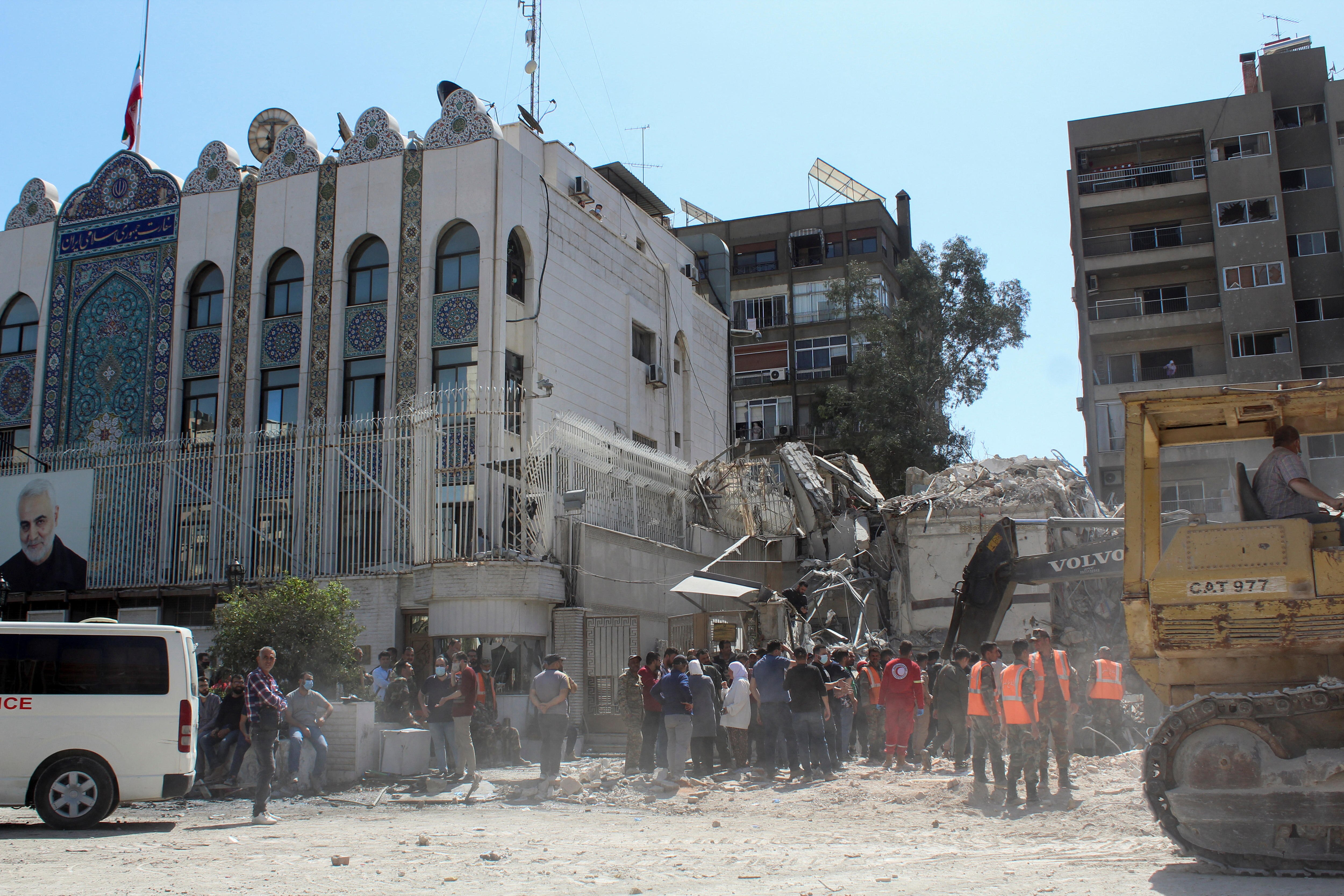 Workers clear rubble from a destroyed building