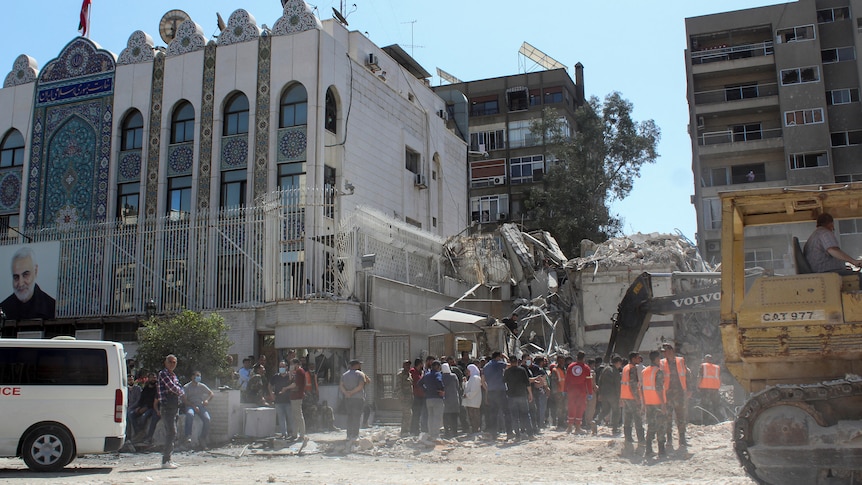 Workers clear rubble from a destroyed building