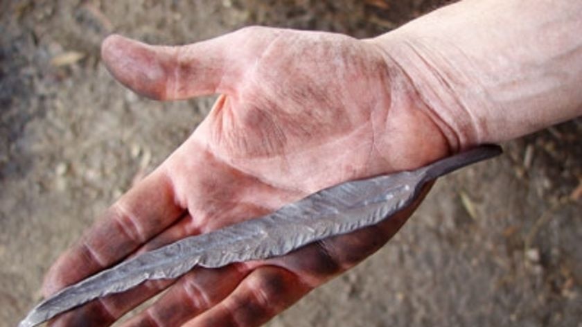 A hand holds a steel gum leaf in March 2009 as part of a project to create a memorial tree for the V