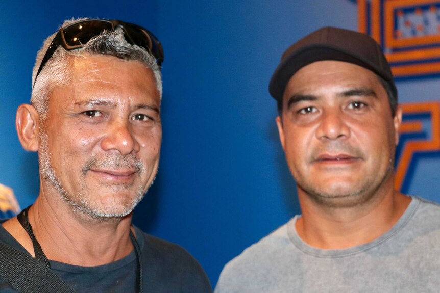 A tight head and shoulders shot of West Kimberley artists and brothers Garry and Darrell Sibosado standing side by side.