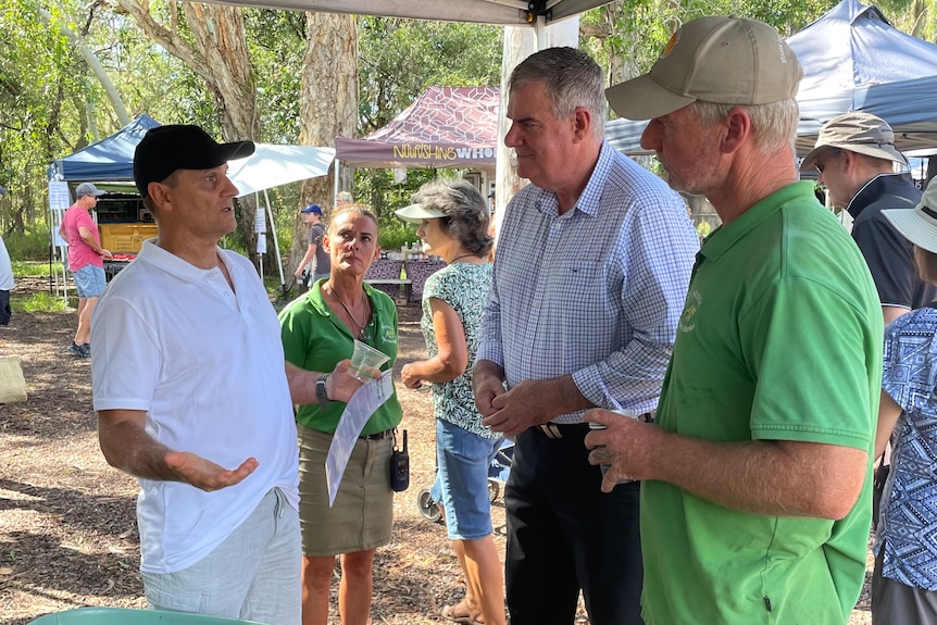 Man in blue business shirt at food market with others