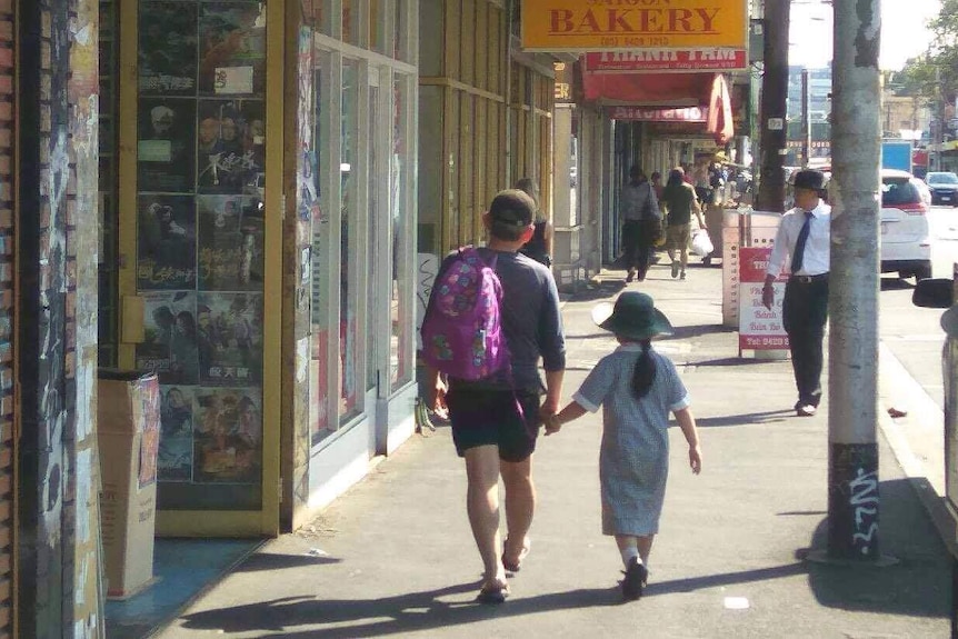 A man walks with a girl along Victoria Street in Richmond.