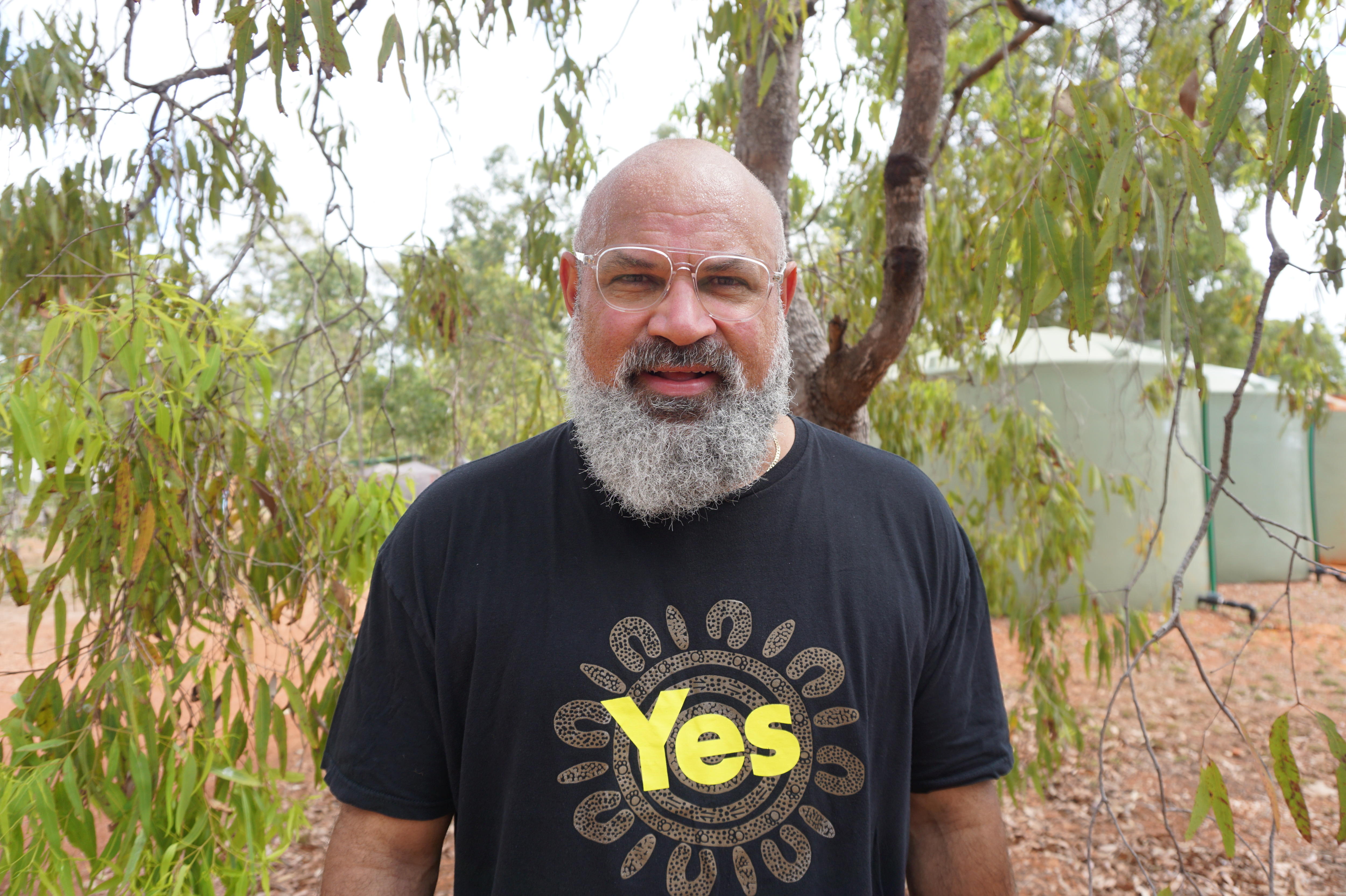 Kenny Bedford stands at Garma festival wearing a black t-shirt with 'yes' on it 