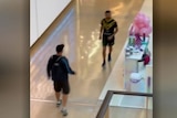 A man confronts another man who holds a knife in a shopping centre.